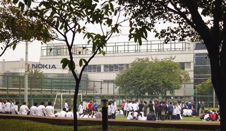 Nokia factory workers protest on a football pitch outside the factory in Dongguan, Guangdong province
